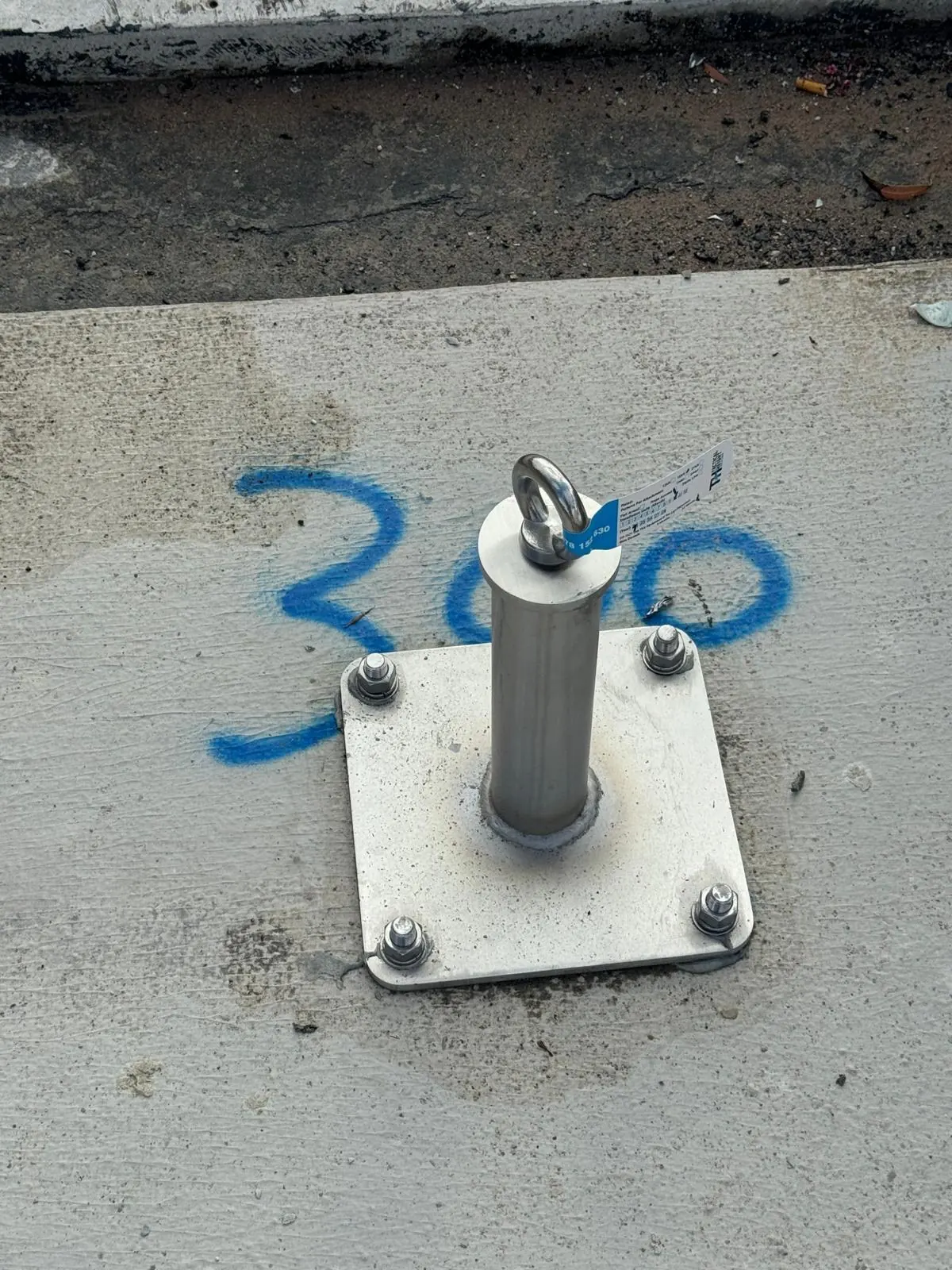 Newly installed roof anchor plate on a concrete roof