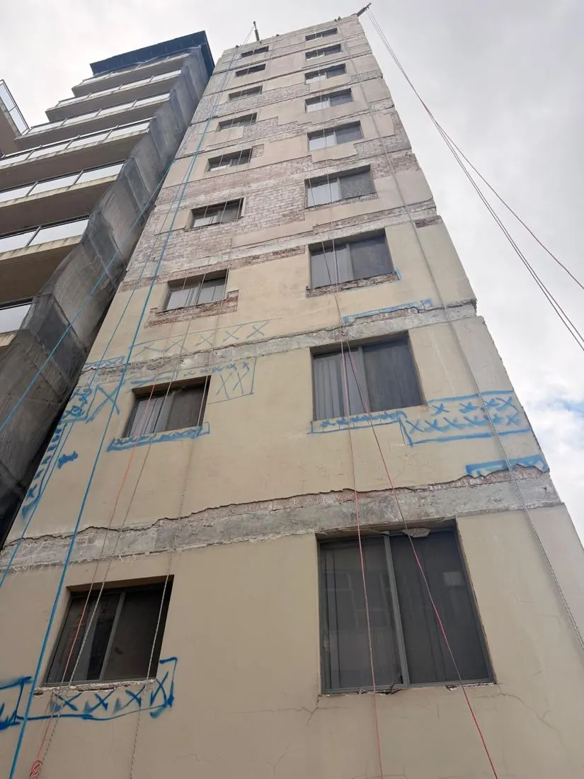 Concrete cracks and spalling marked in blue survey paint during a façade inspection on a Bankstown high-rise