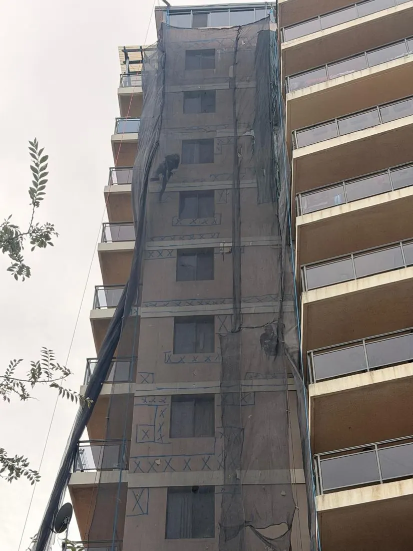 Containment netting hung down the full height of a Bankstown high-rise during concrete repairs