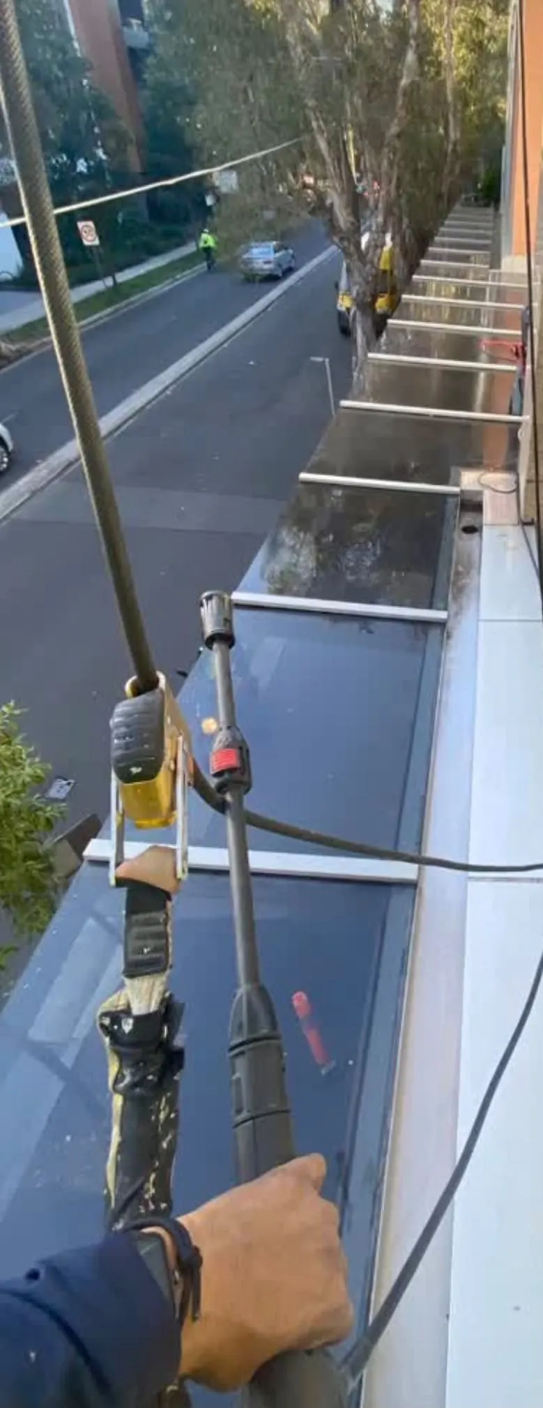 Flushing out the box gutter of a glass entrance canopy from the rope