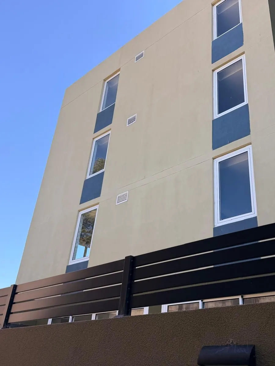 The same Mascot apartment building after render repairs and repainting, with no visible repair band
