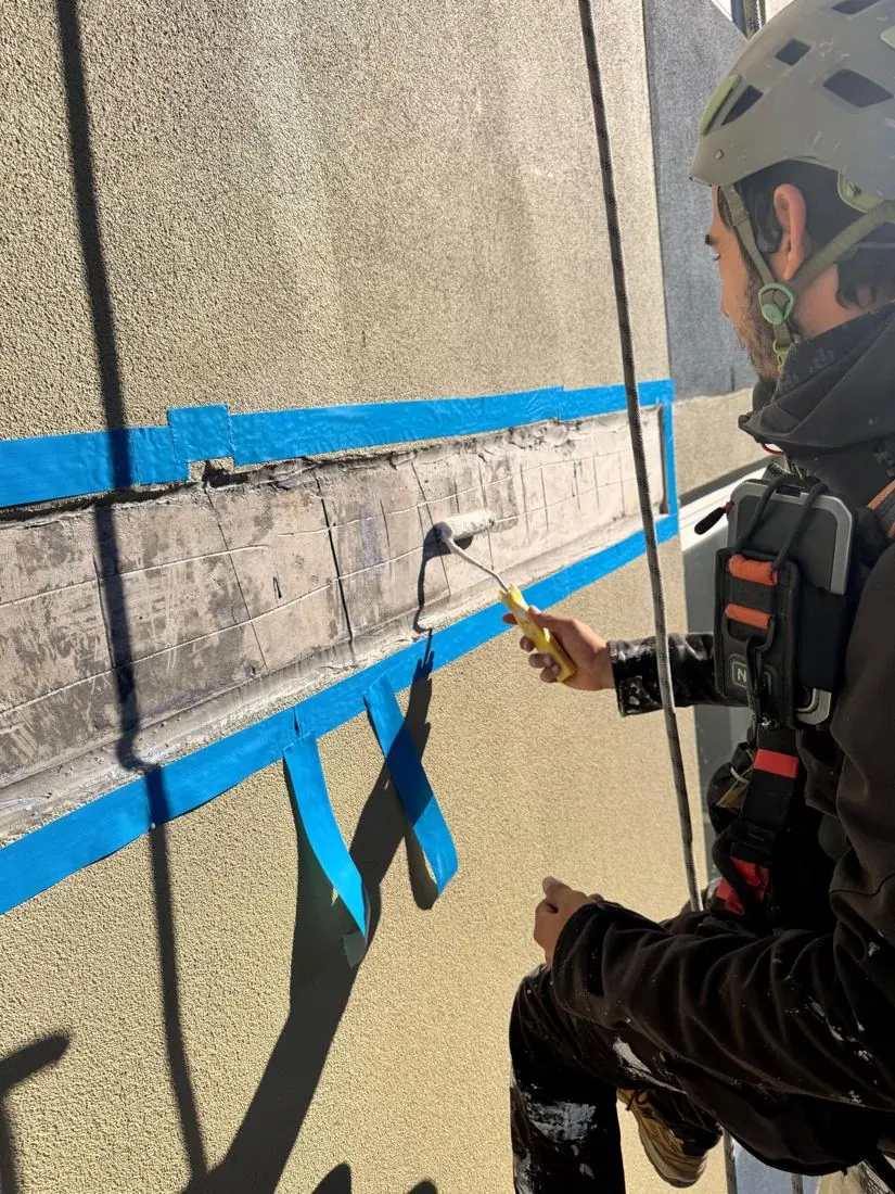 Bonding primer rolled onto the prepared slab edge before the render repair