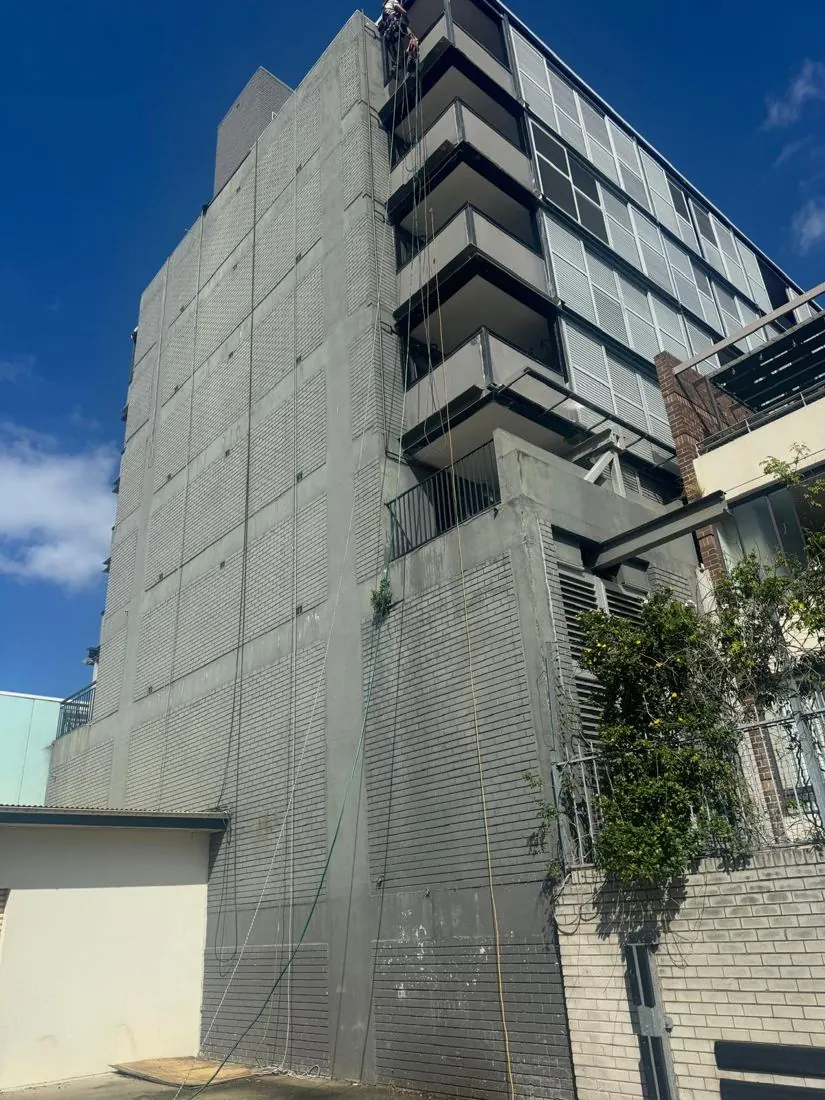 Brick side elevation of a Randwick residential tower with a patchy finish before repainting