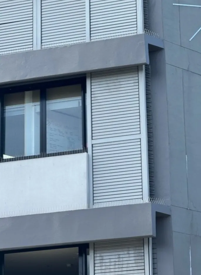Finished hotel façade in Randwick with bird spikes along the ledges above the louvres